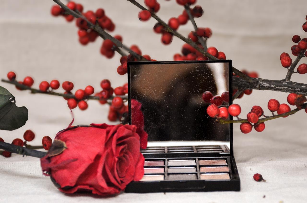 Palette de maquillage avec rose rouge et branches de baies